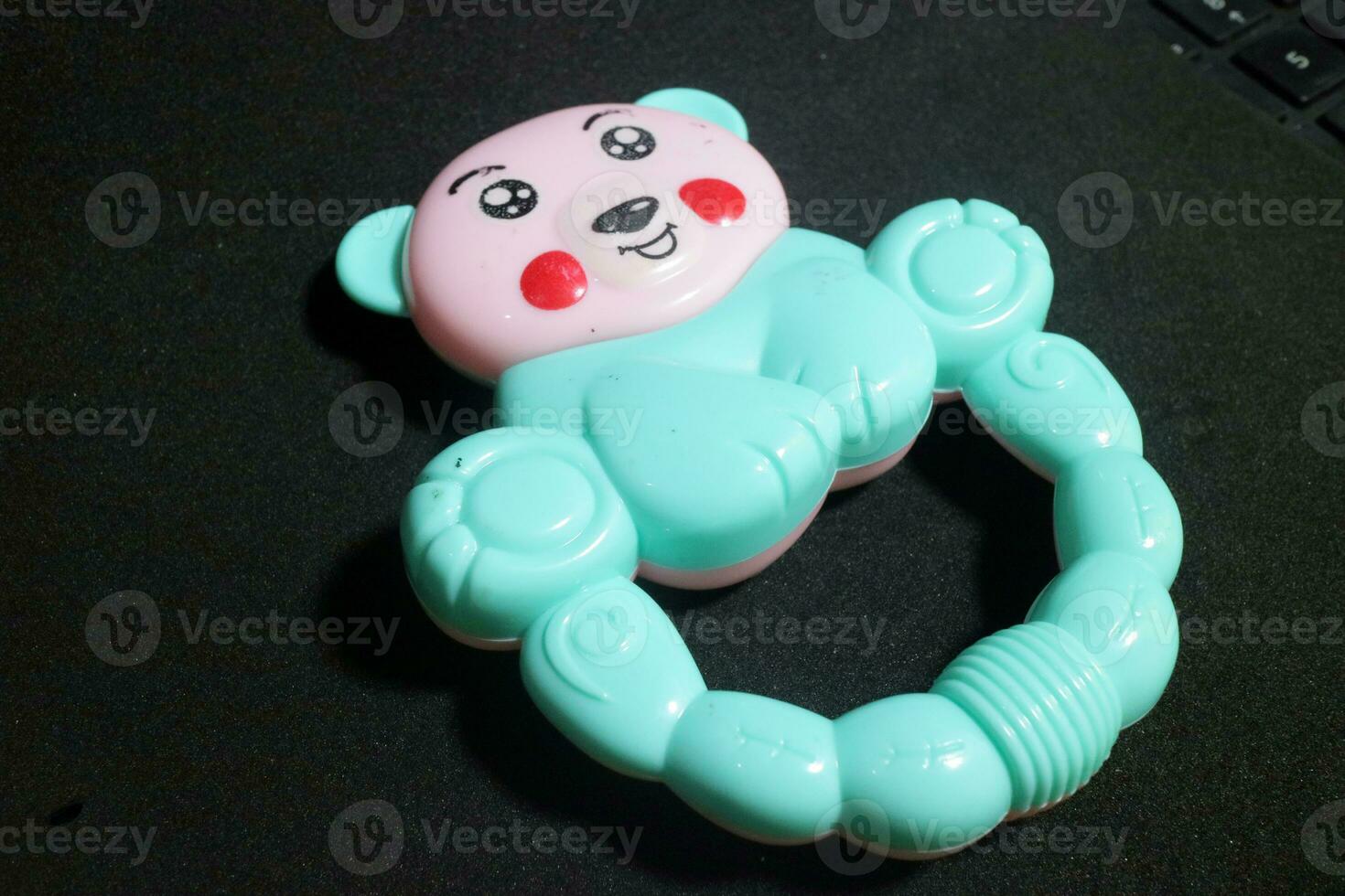 Pink blue baby holding toy with clown face photo