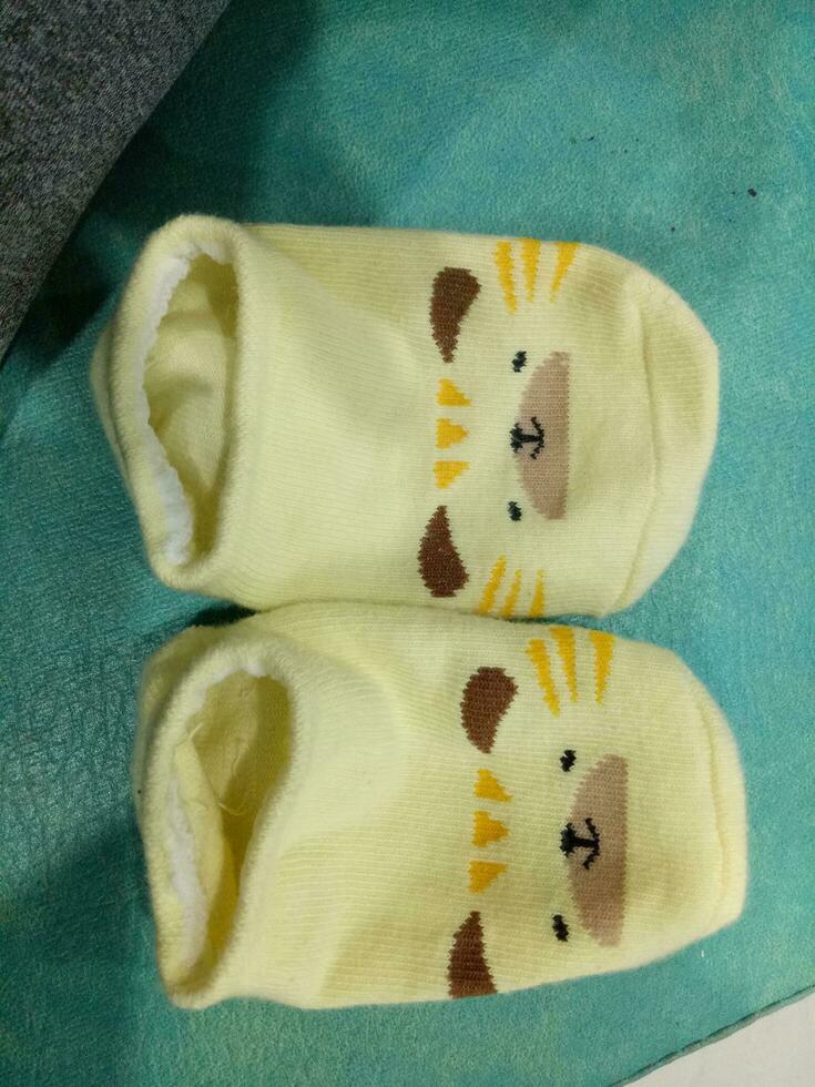 Cute baby socks in yellow and a guinea pig face photo