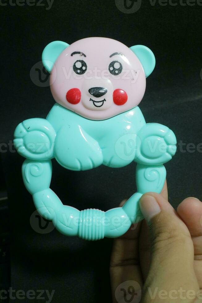 Pink blue baby holding toy with clown face photo