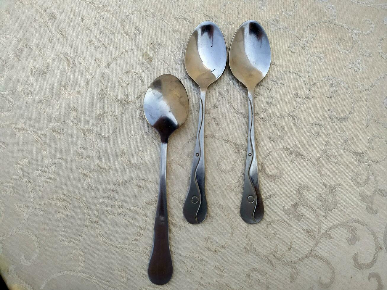 several aluminum spoons arranged uniquely on the table photo