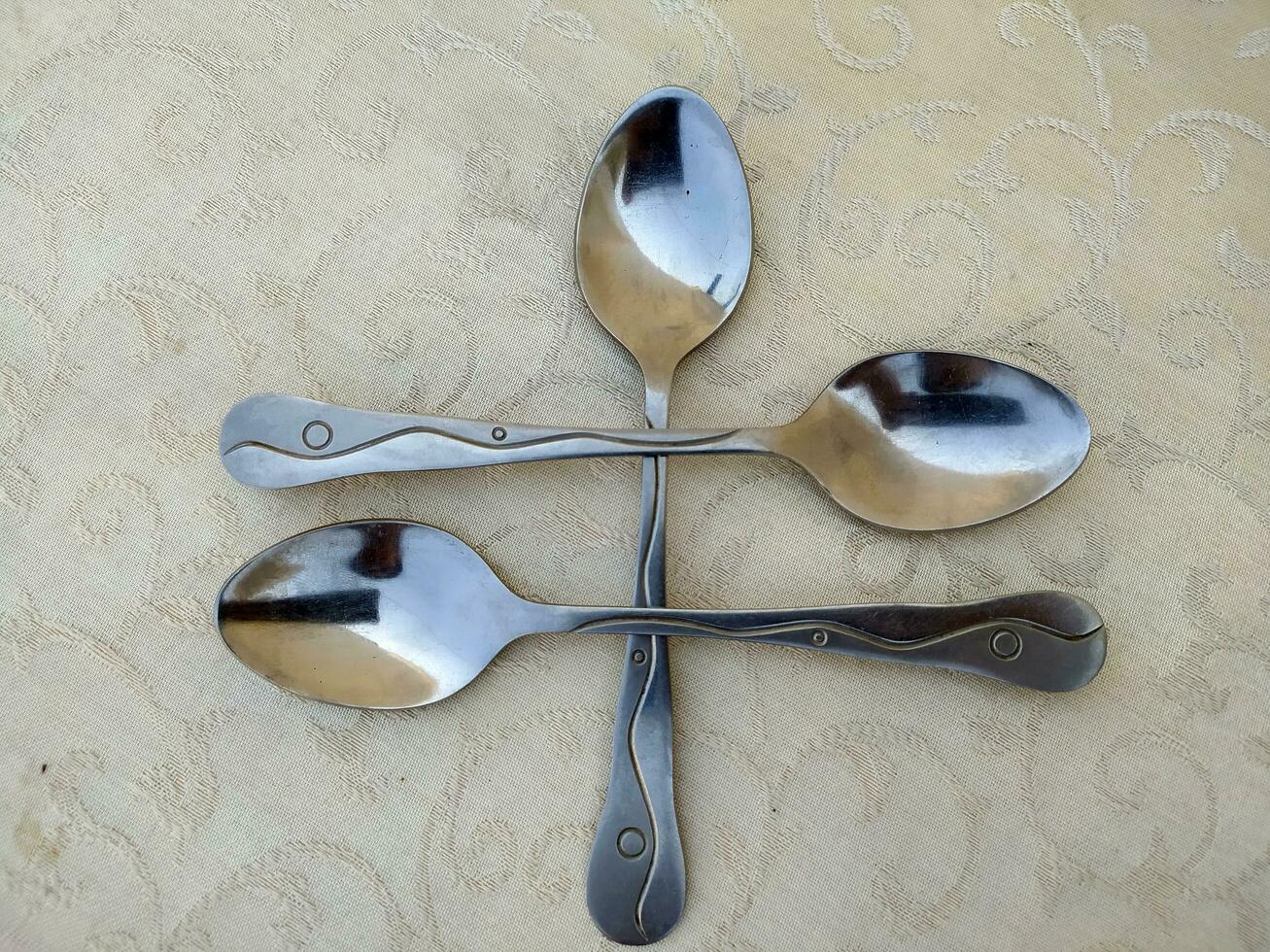 several aluminum spoons arranged uniquely on the table photo