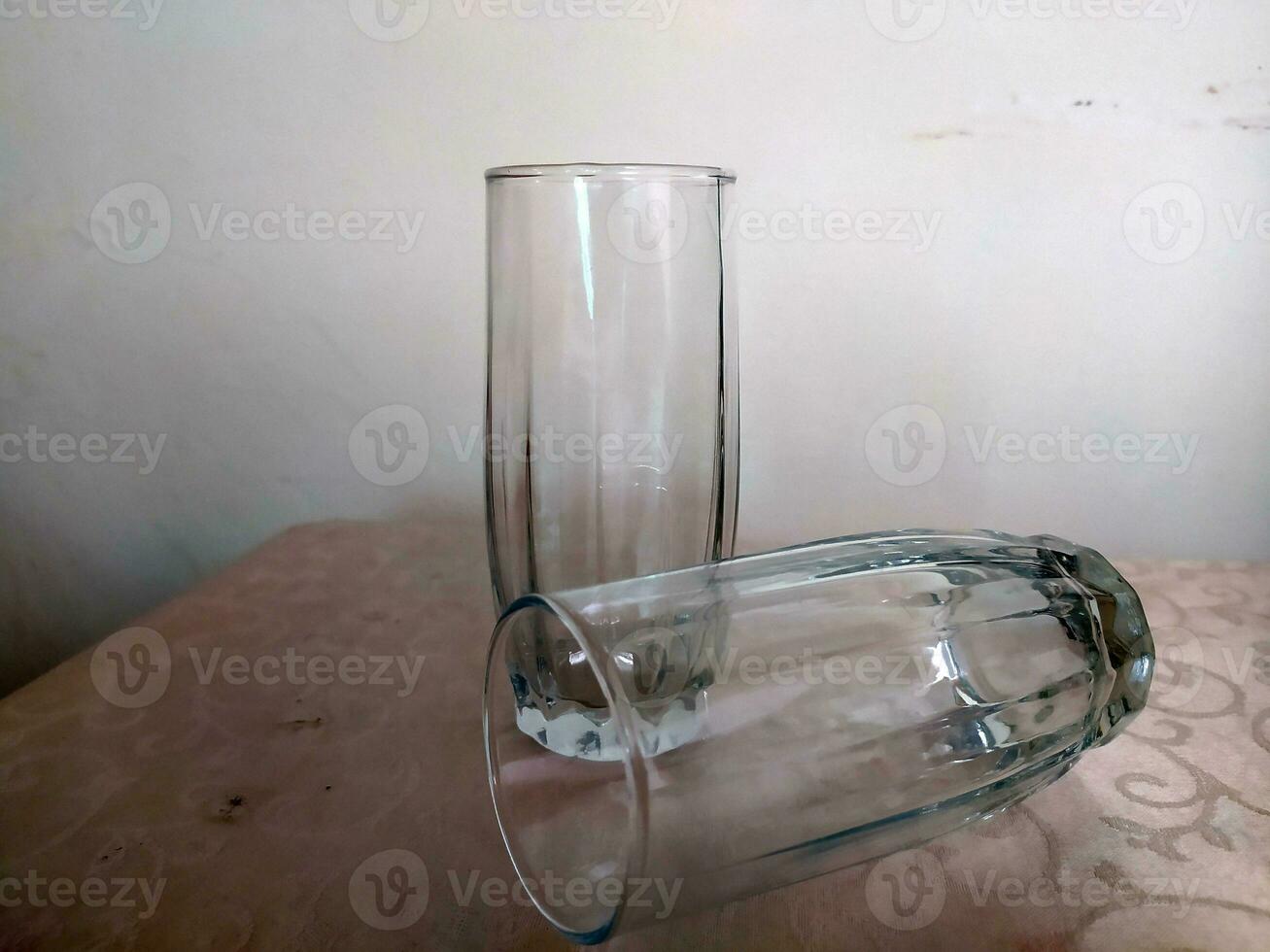 Clear white drinking glass made of glass with an elongated shape photo