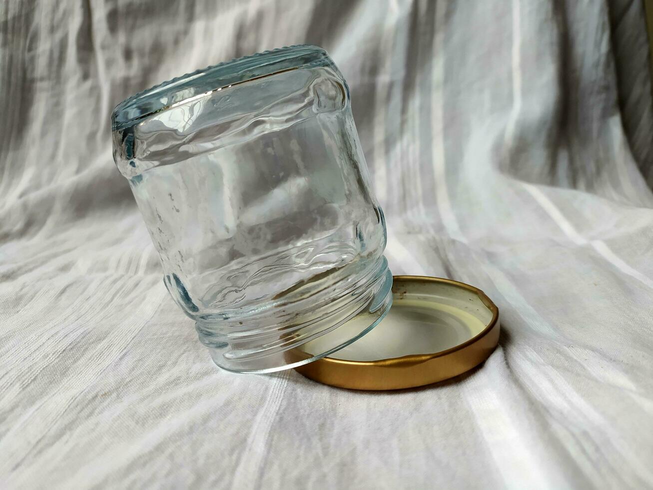 An empty glass jar with a golden lid photo