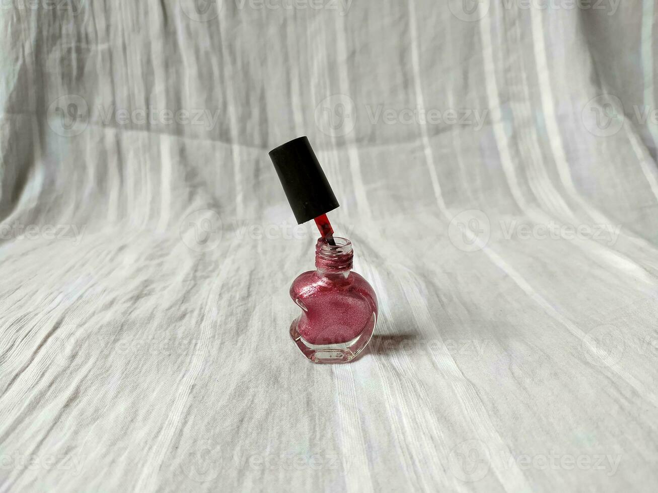 A pink nail polish with a unique half heart shaped bottle photo