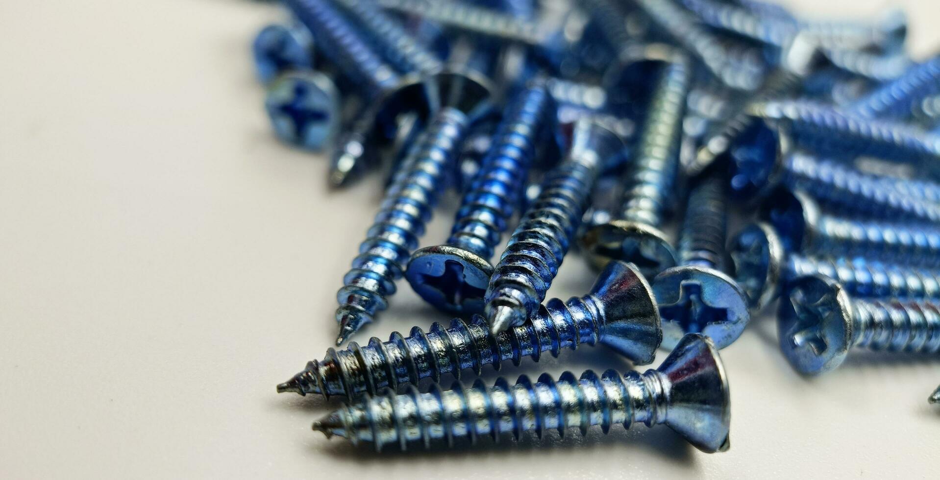 Tapping screws made of steel on Gray background, metal screw, iron screw, chrome screw, screws as a background, wood screw, concept industry. photo