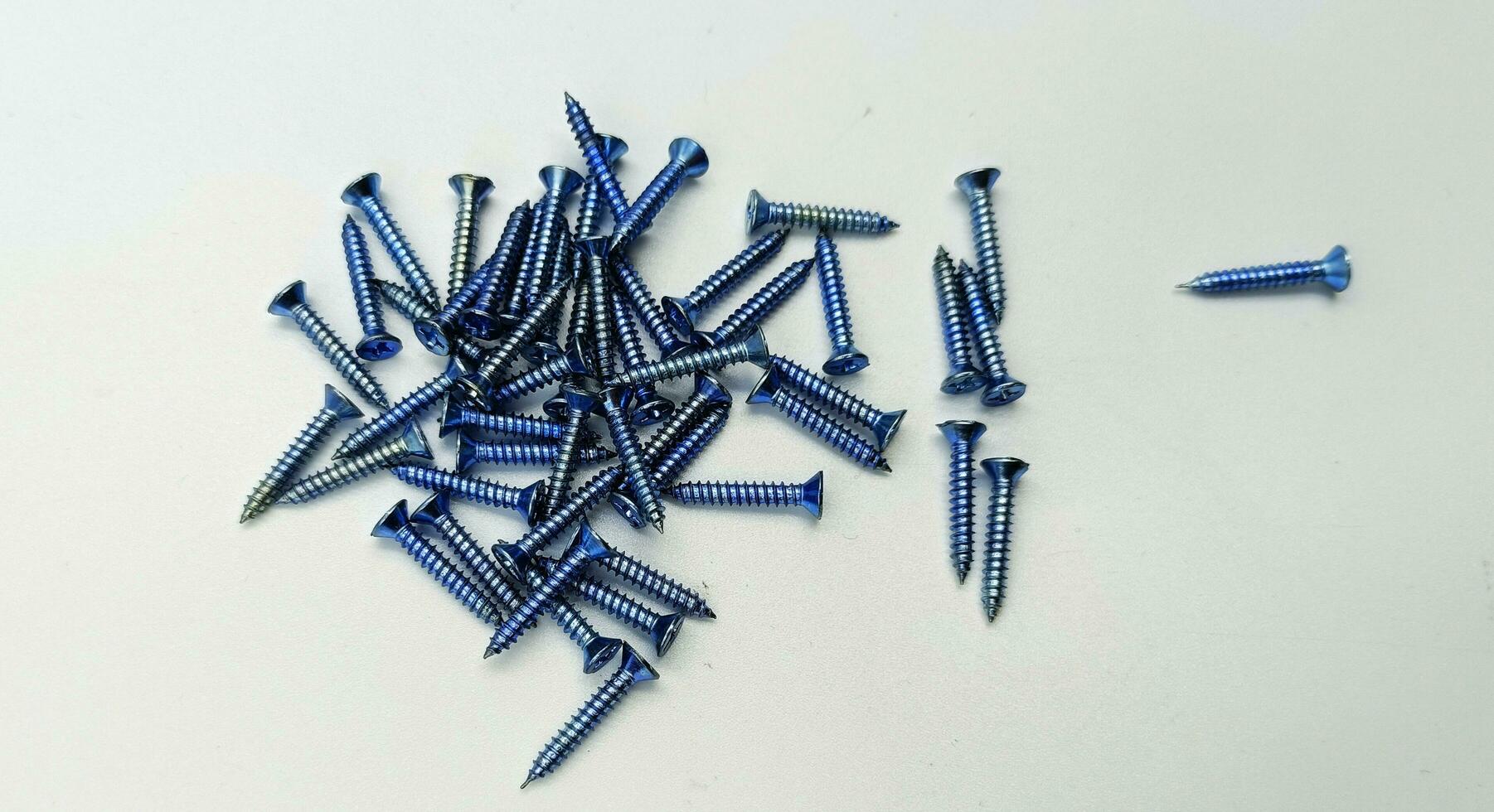 Tapping screws made of steel on Gray background, metal screw, iron screw, chrome screw, screws as a background, wood screw, concept industry. photo