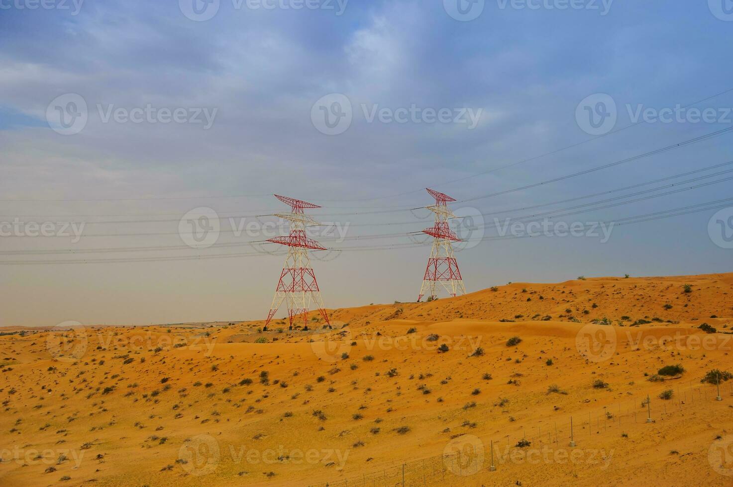 Yelow desert with electricity stands on skyline. photo