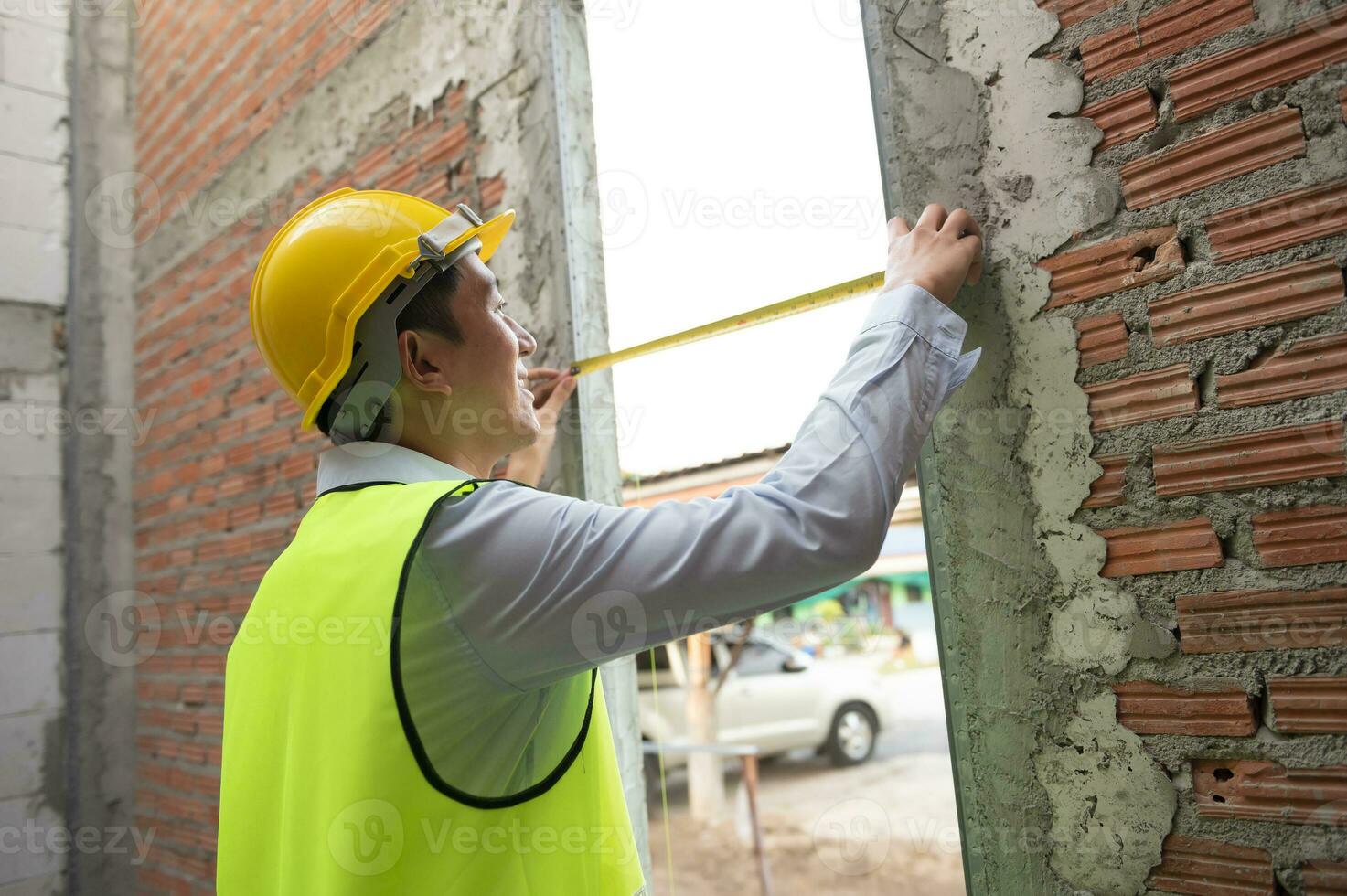 An Asian Engineering man wearing safety helmet checking construction site analyzing about project progress photo