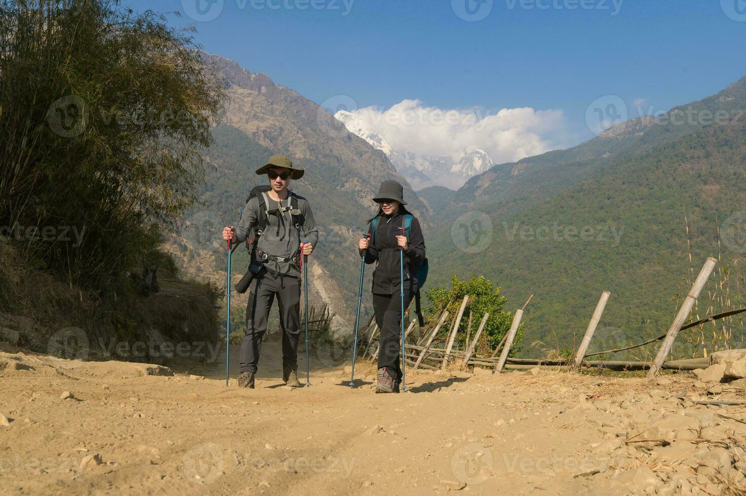 un joven Pareja viajeros trekking en poon colina ver punto en ghorepani, Nepal foto