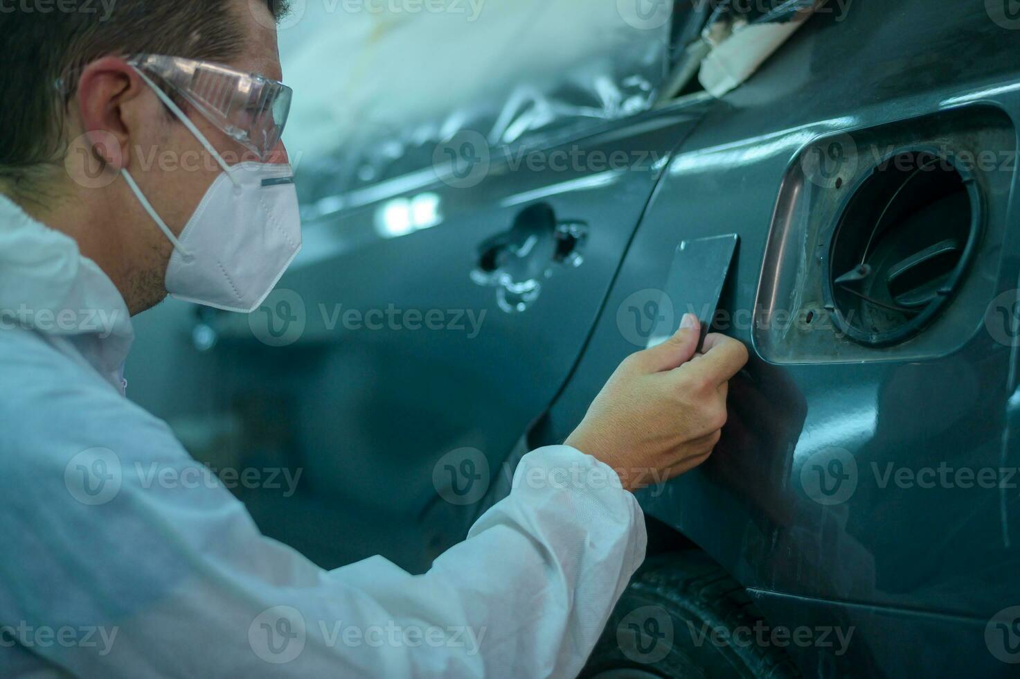caucasian man is checking color painting in repair mechanic painting shop photo