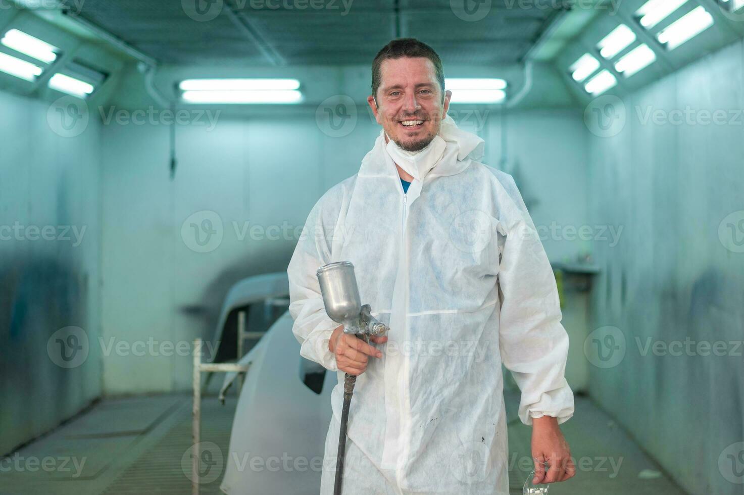 is using painting gun in repair mechanic painting shop photo