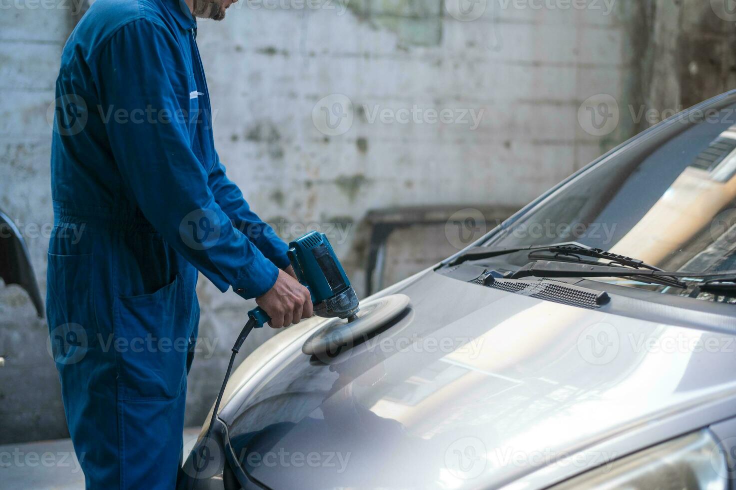 Close-up  man hand is using car polishing machine in repair mechanic painting shop photo