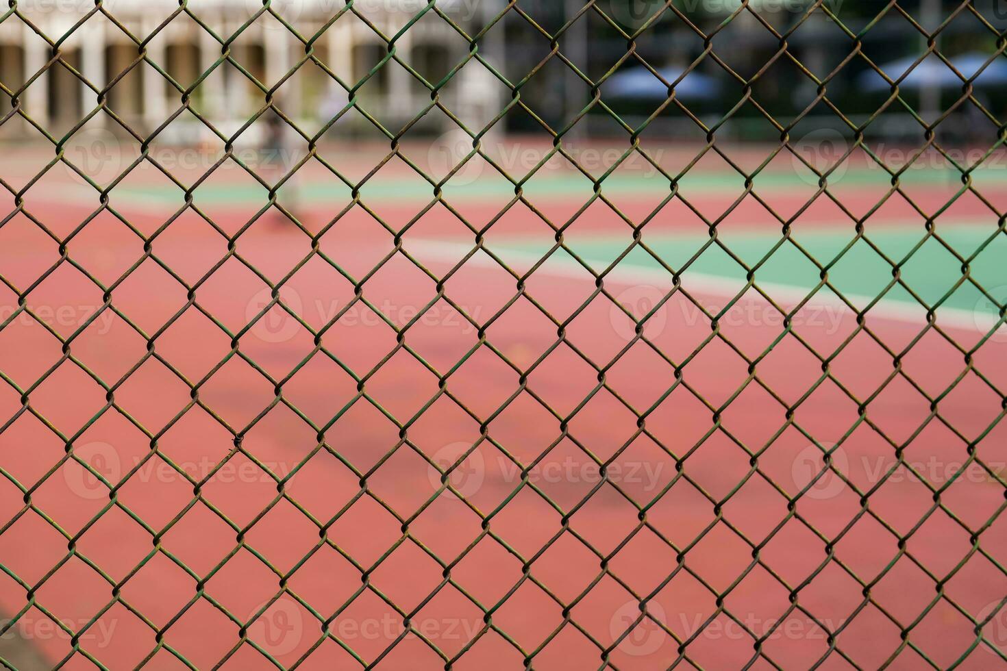 Metal mesh on a blurred background of a tennis court with players. photo
