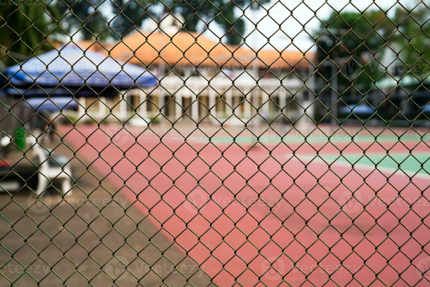 Metal mesh on a blurred background of a tennis court with players. photo
