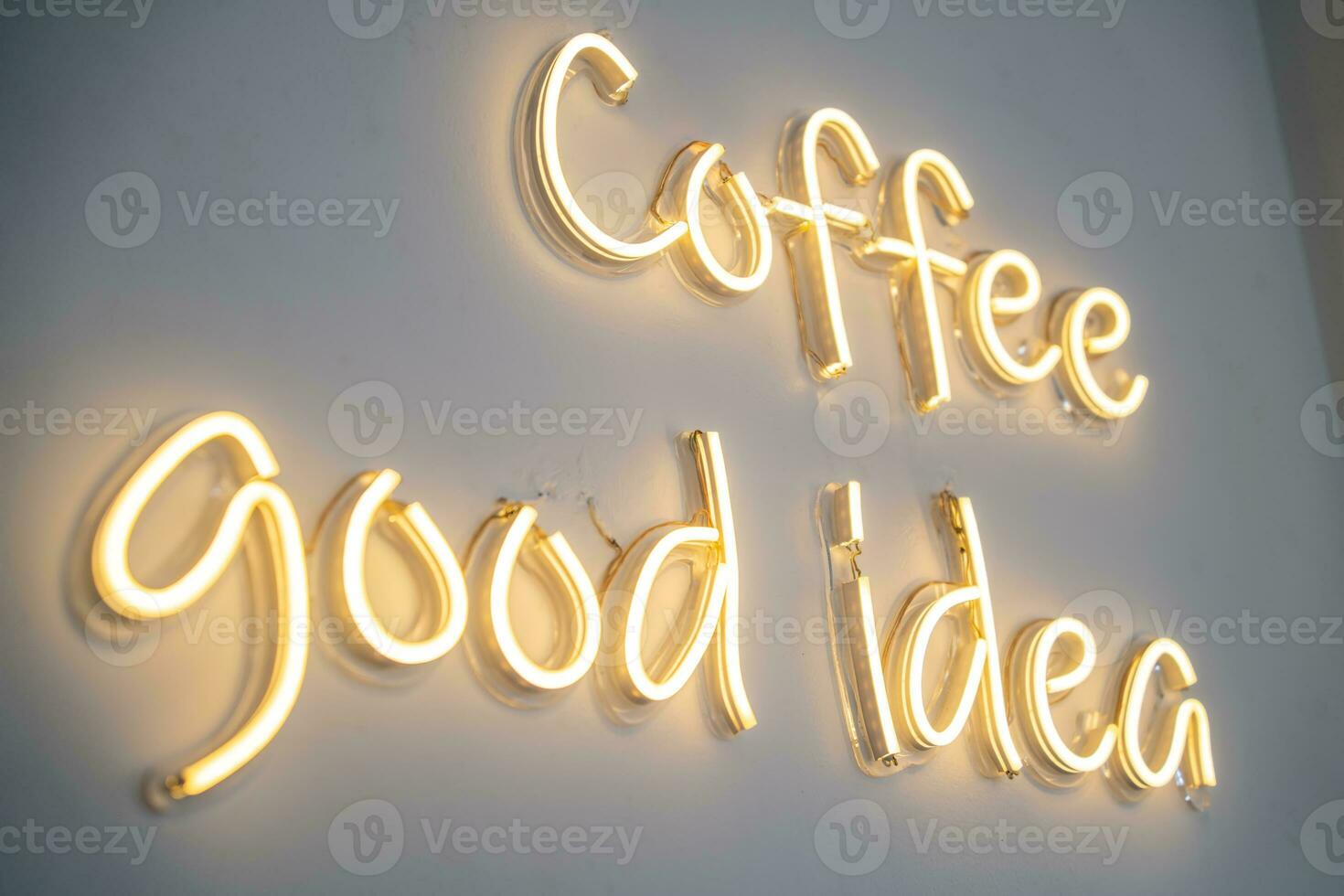 A yellow neon sign on white wall at coffee shop. photo