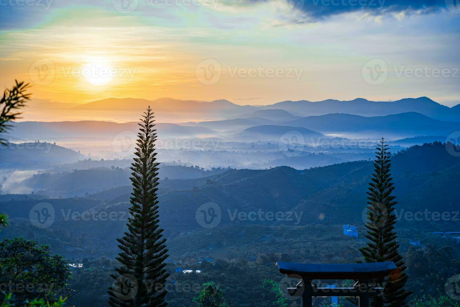 Mountain range with visible silhouettes through the morning colorful fog photo
