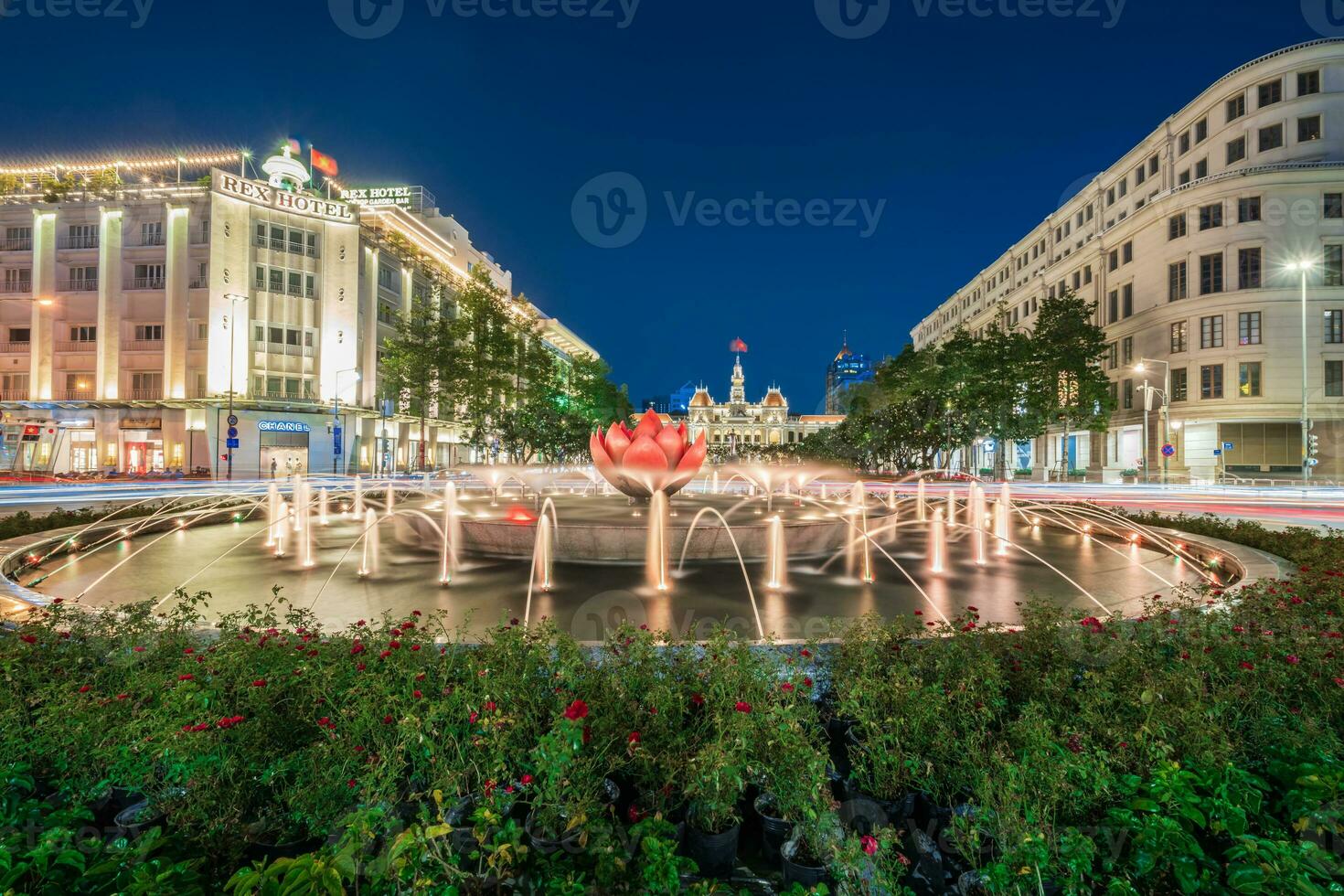 Ho Chi Minh, Viet Nam - 10 April 2023 Saigon City Hall, Vincom Center towers, colorful street traffic and tropical plants against the amazing night. Saigon downtown with its famous landmarks. photo