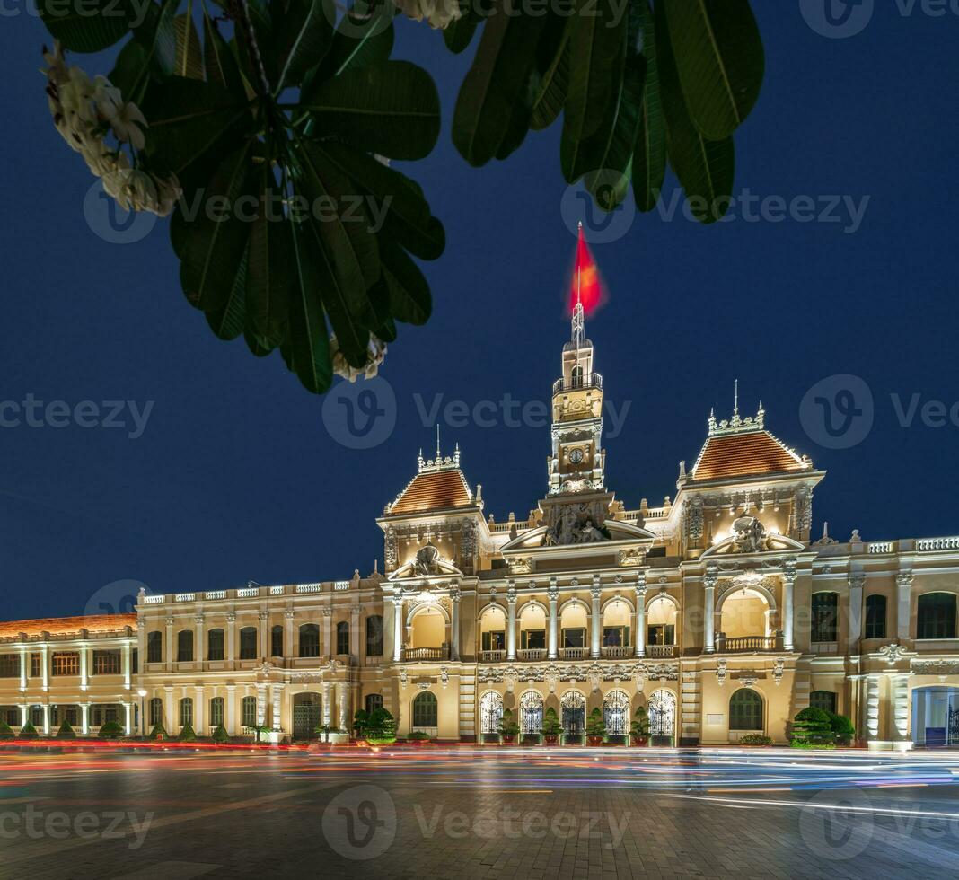 Ho Chi Minh, Viet Nam - 10 April 2023 Saigon City Hall, Vincom Center towers, colorful street traffic and tropical plants against the amazing night. Saigon downtown with its famous landmarks. photo