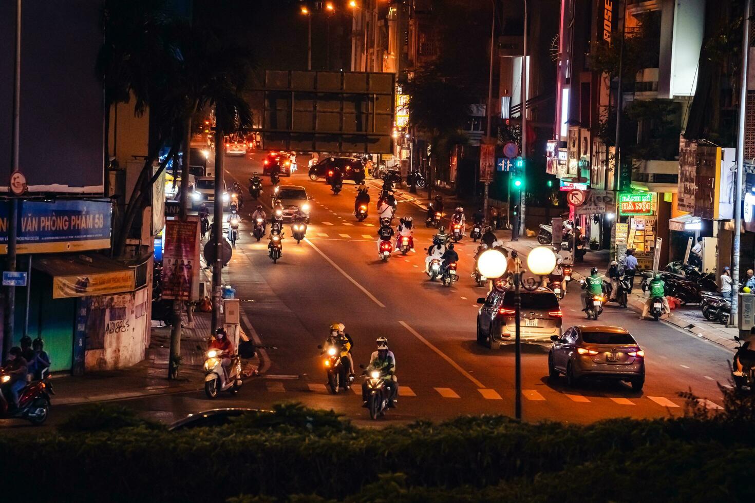 Ho Chi Minh City, Vietnam - Apr 14, 2023 Traffic jam at Dien Bien Phu roundabout with its four-faced clock tower a symbol of Ho Chi Minh city. Light trail from cars. photo