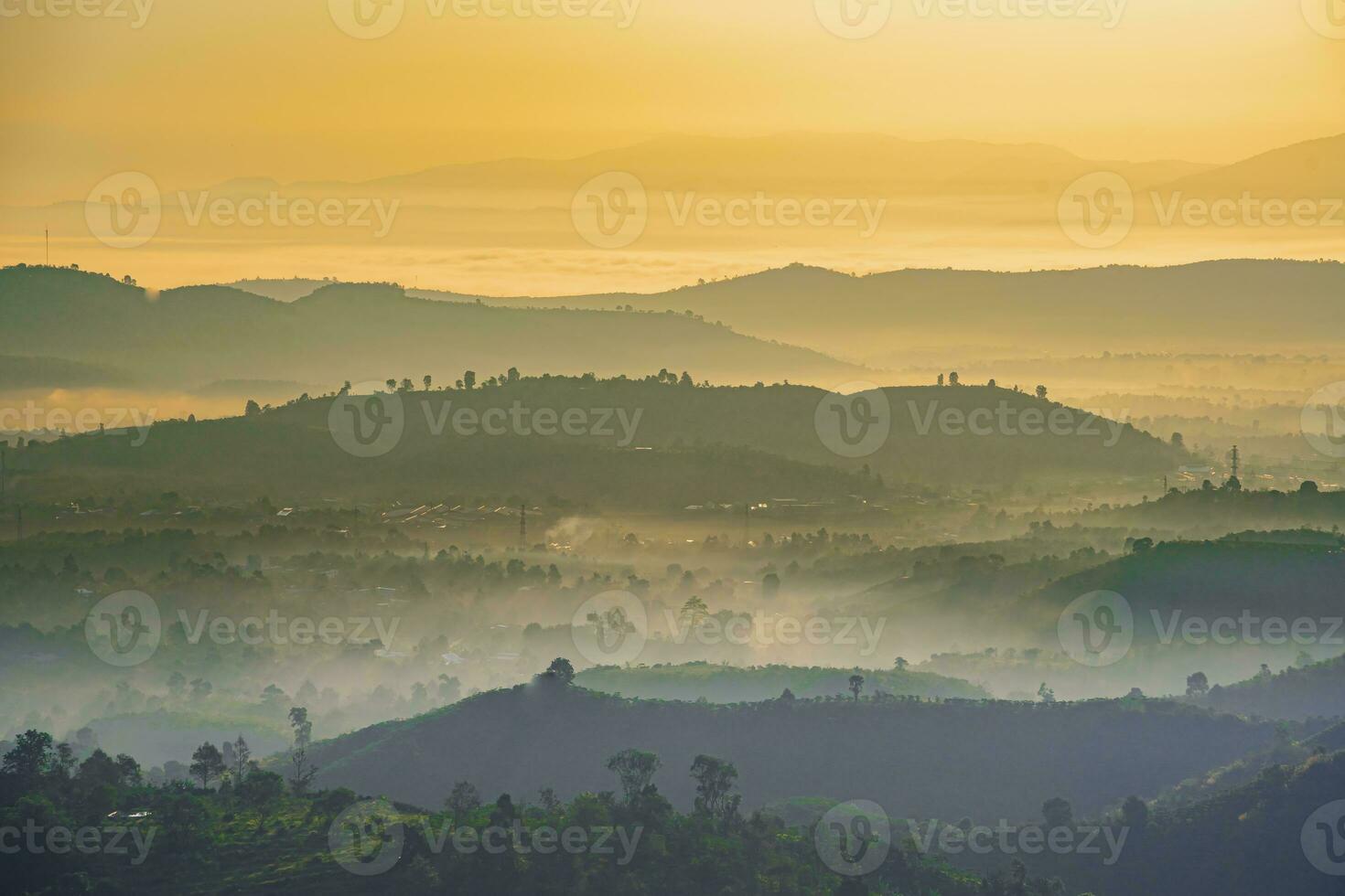 Mountain range with visible silhouettes through the morning colorful fog photo