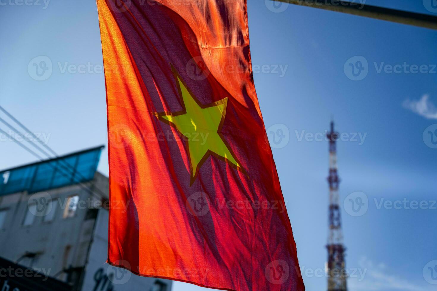 Vietnamese flag waving in the wind on a pole against a blue sky background photo