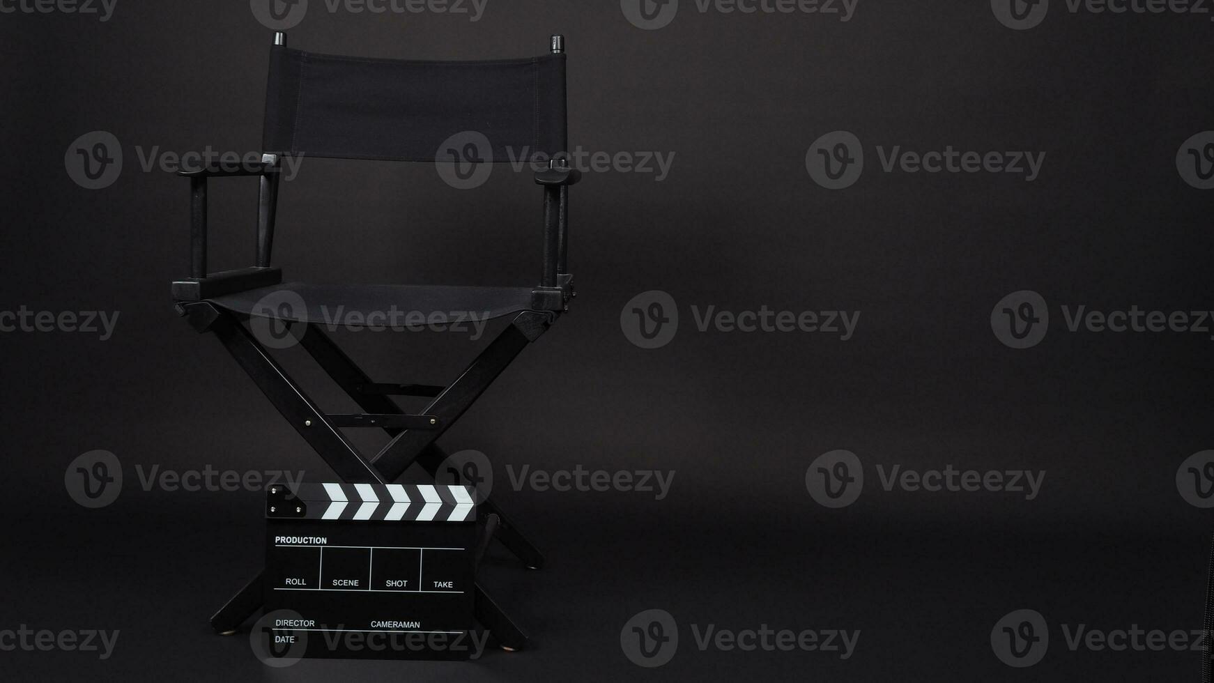 director chair and Clapperboard or movie slate use in video production ,film, cinema industry on black background. photo