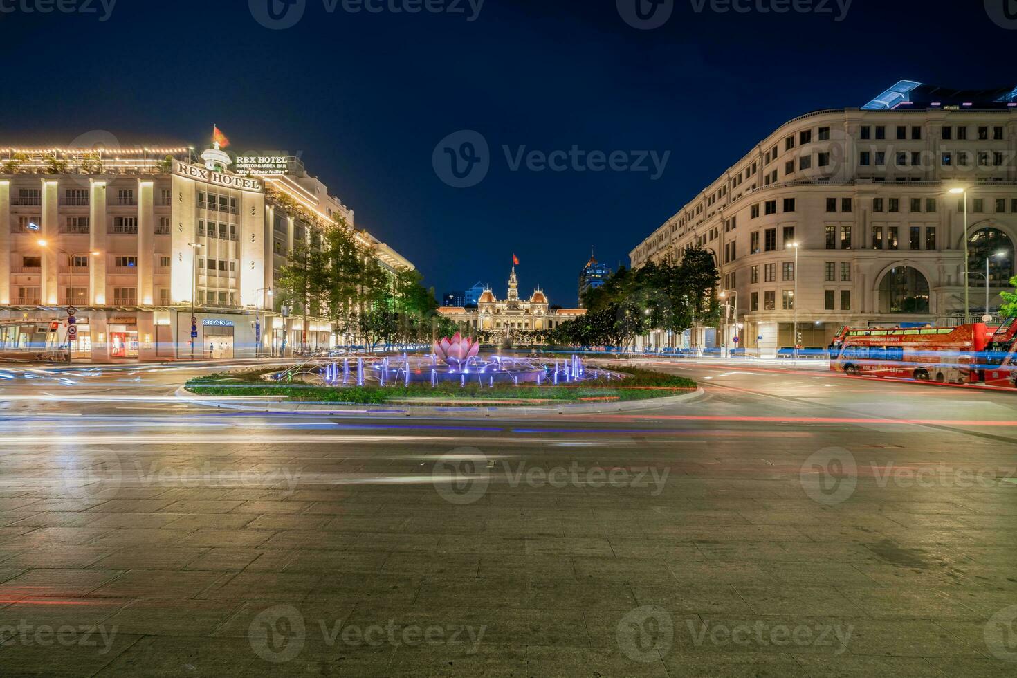 Ho Chi Minh, Viet Nam - 10 April 2023 Saigon City Hall, Vincom Center towers, colorful street traffic and tropical plants against the amazing night. Saigon downtown with its famous landmarks. photo