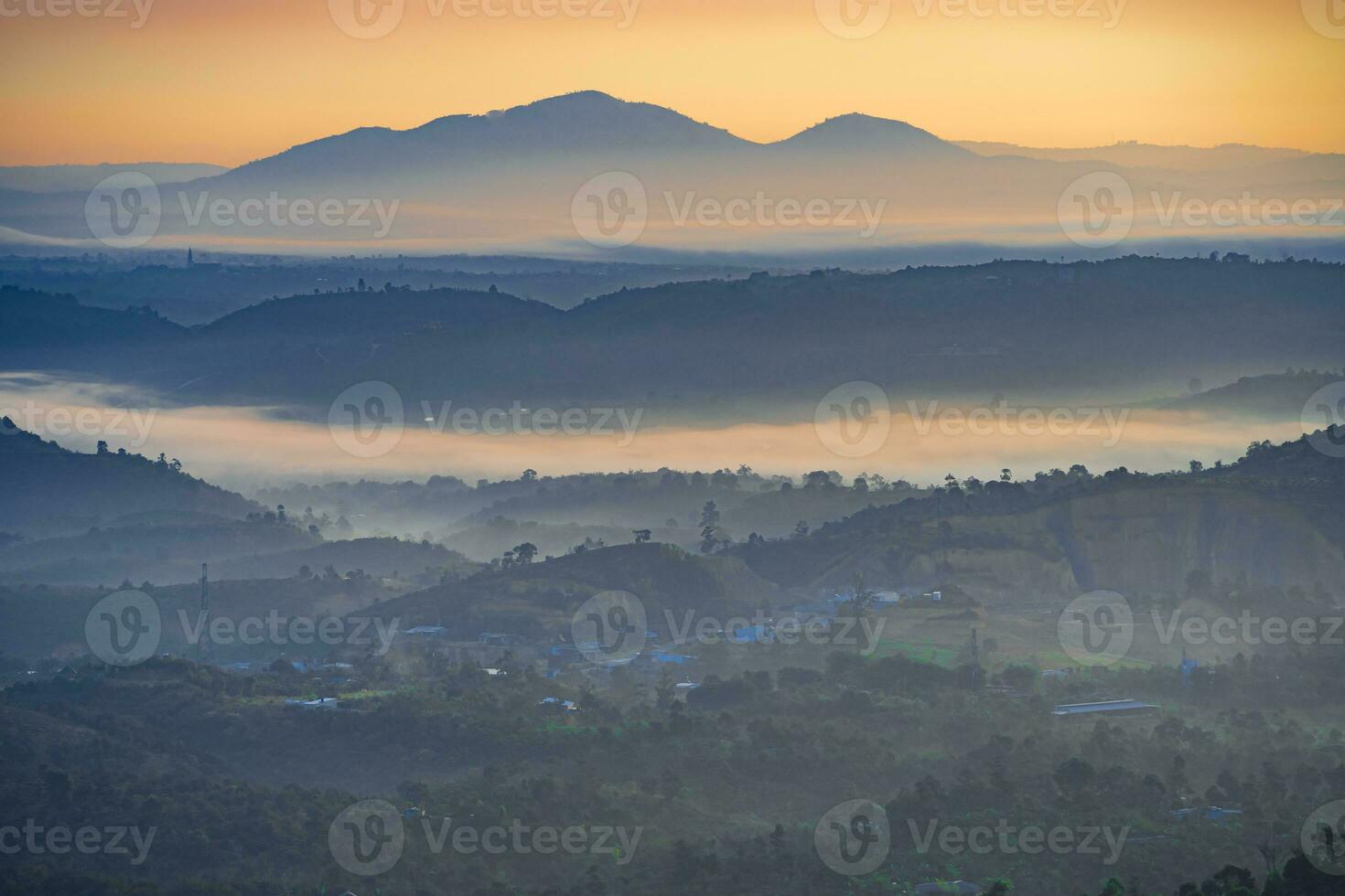 Mountain range with visible silhouettes through the morning colorful fog photo