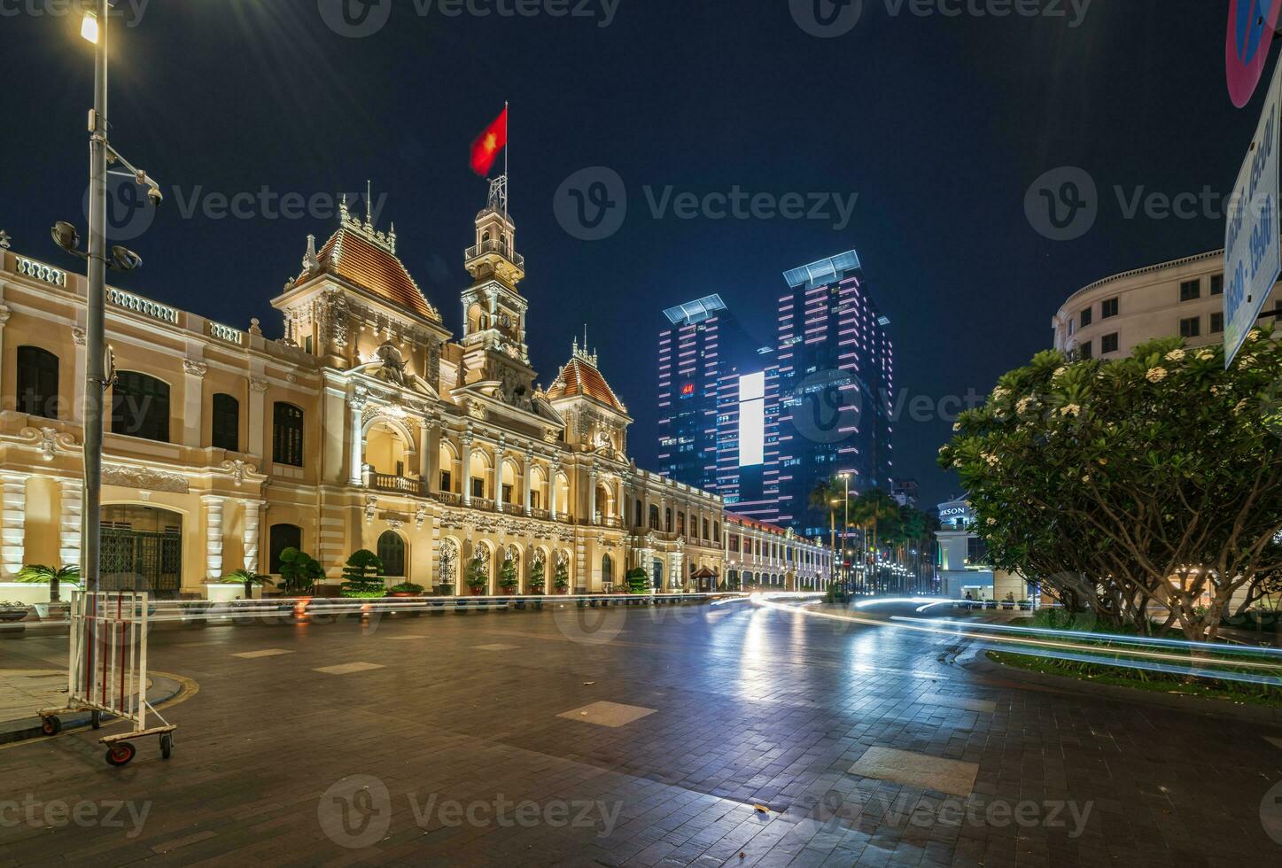 Ho Chi Minh, Viet Nam - 10 April 2023 Saigon City Hall, Vincom Center towers, colorful street traffic and tropical plants against the amazing night. Saigon downtown with its famous landmarks. photo