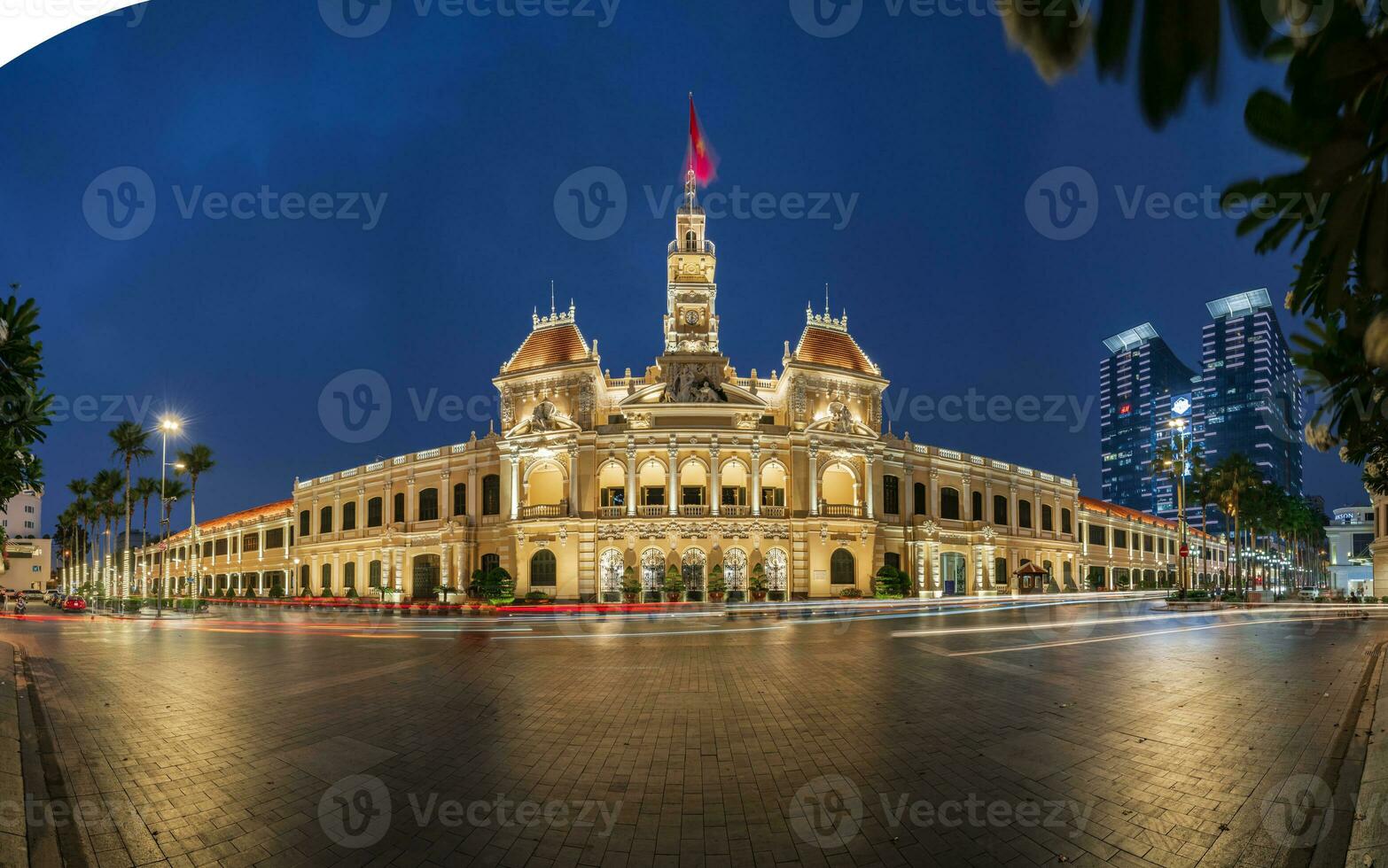 Ho Chi Minh, Viet Nam - 10 April 2023 Saigon City Hall, Vincom Center towers, colorful street traffic and tropical plants against the amazing night. Saigon downtown with its famous landmarks. photo