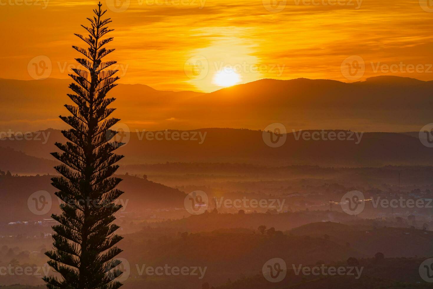 Mountain range with visible silhouettes through the morning colorful fog photo