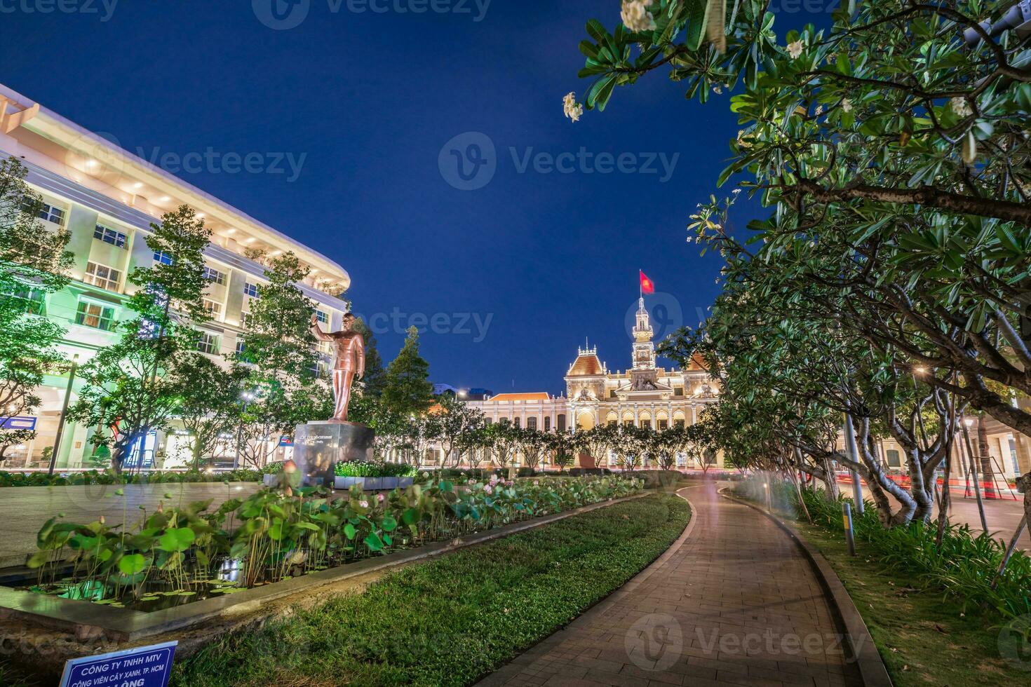 Ho Chi Minh, Viet Nam - 10 April 2023 Saigon City Hall, Vincom Center towers, colorful street traffic and tropical plants against the amazing night. Saigon downtown with its famous landmarks. photo