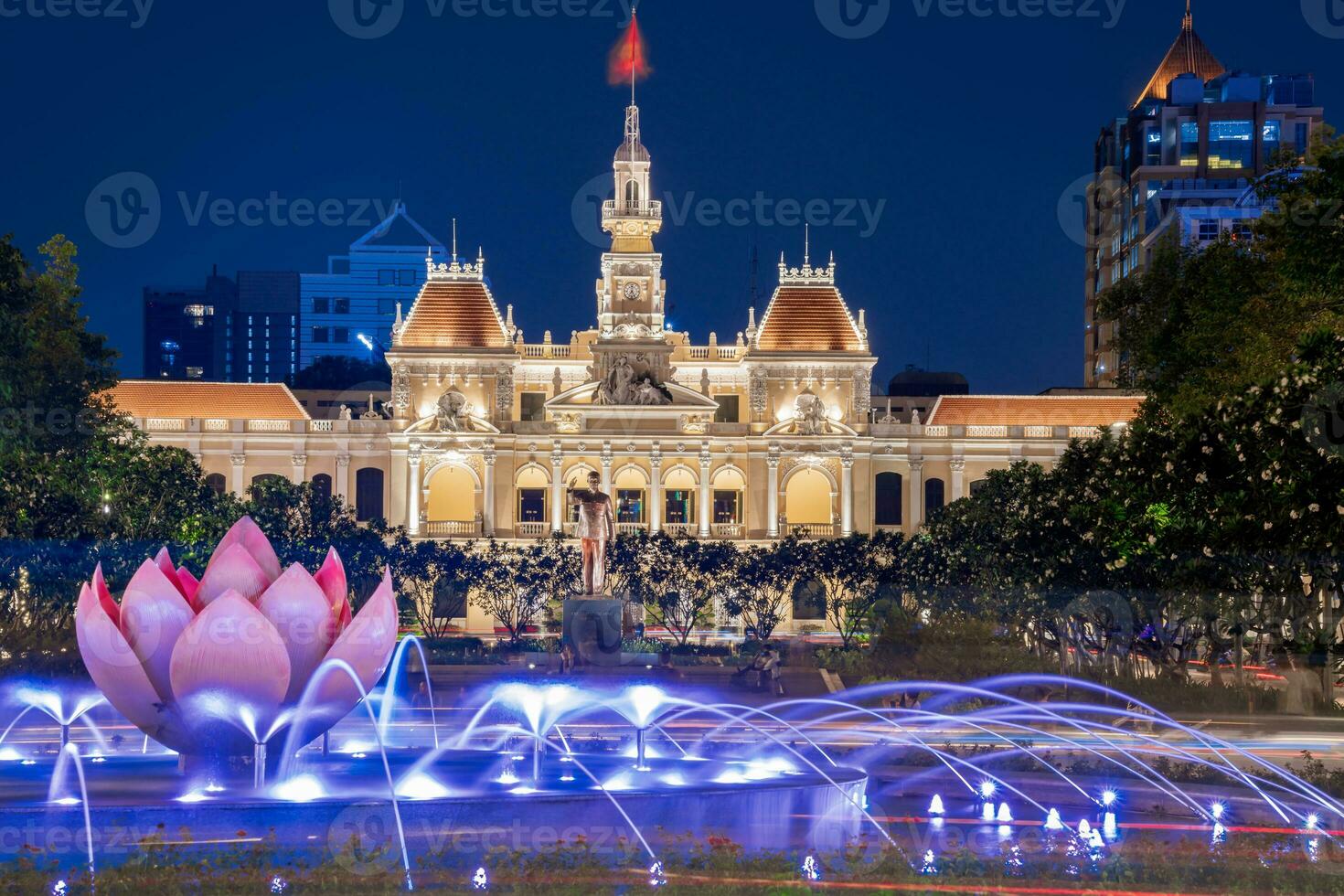 Ho Chi Minh, Viet Nam - 10 April 2023 Saigon City Hall, Vincom Center towers, colorful street traffic and tropical plants against the amazing night. Saigon downtown with its famous landmarks. photo