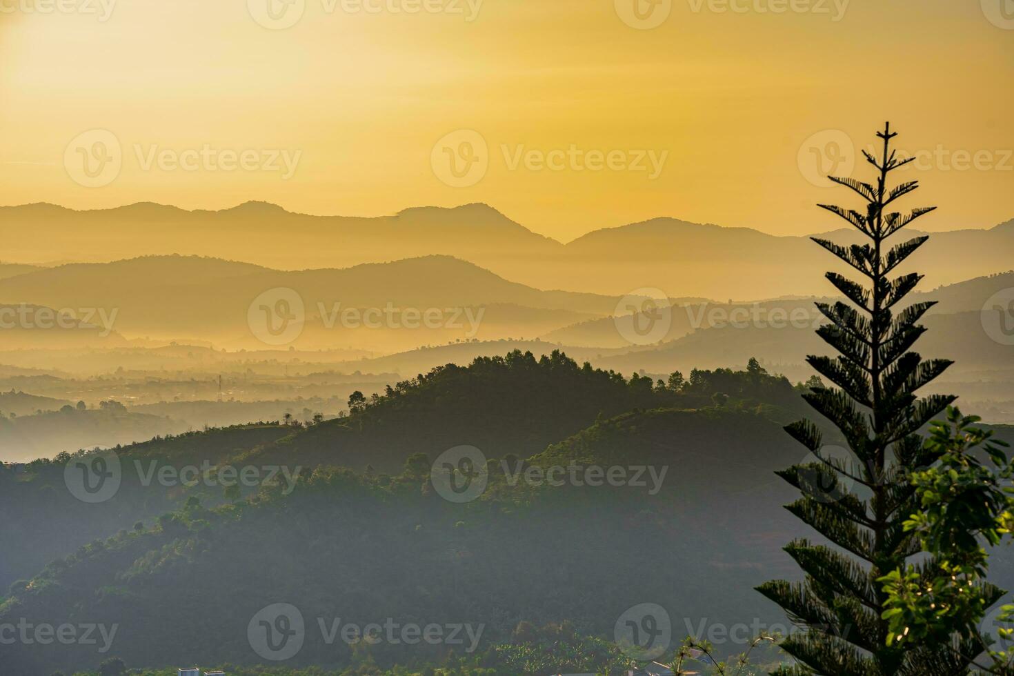 Mountain range with visible silhouettes through the morning colorful fog photo