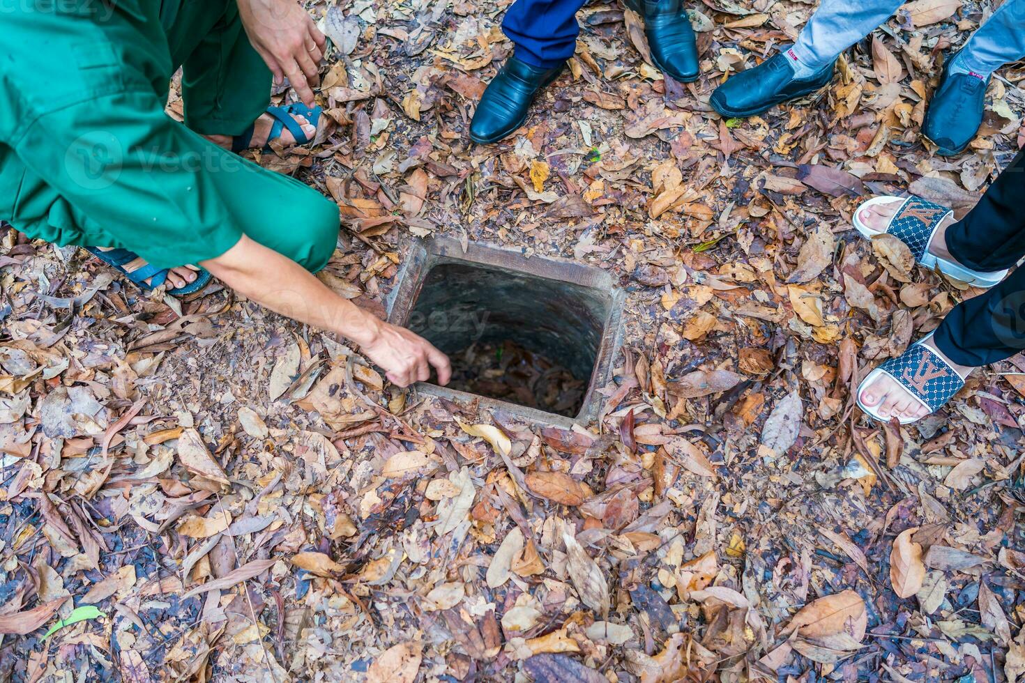 The Cu Chi tunnels. A guide demonstrating how a Vietcong hide into the Tunnel. It's used in Vietnam war. Famous tourist attraction in Vietnam. Stock photo