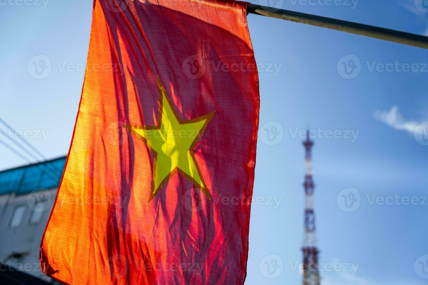 Vietnamese flag waving in the wind on a pole against a blue sky background photo