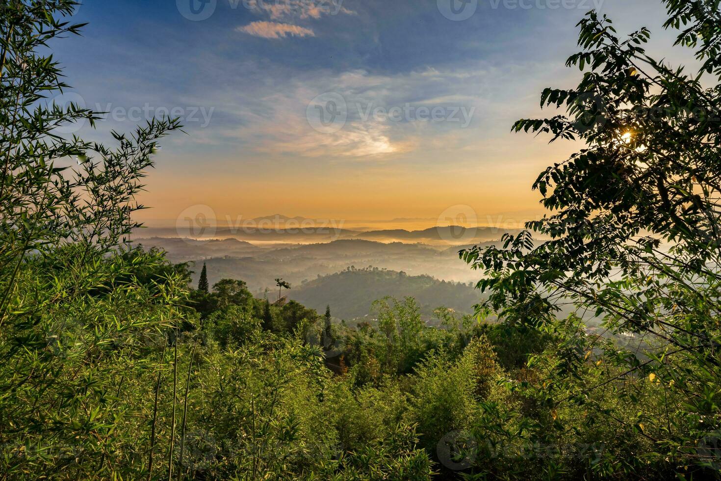 Mountain range with visible silhouettes through the morning colorful fog photo