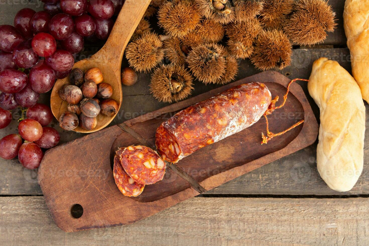 Close up chestnuts chorizo and grapes on rustic wooden table photo