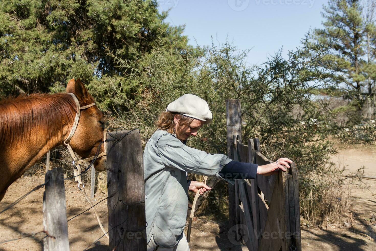 rural woman working in the field leading horse photo
