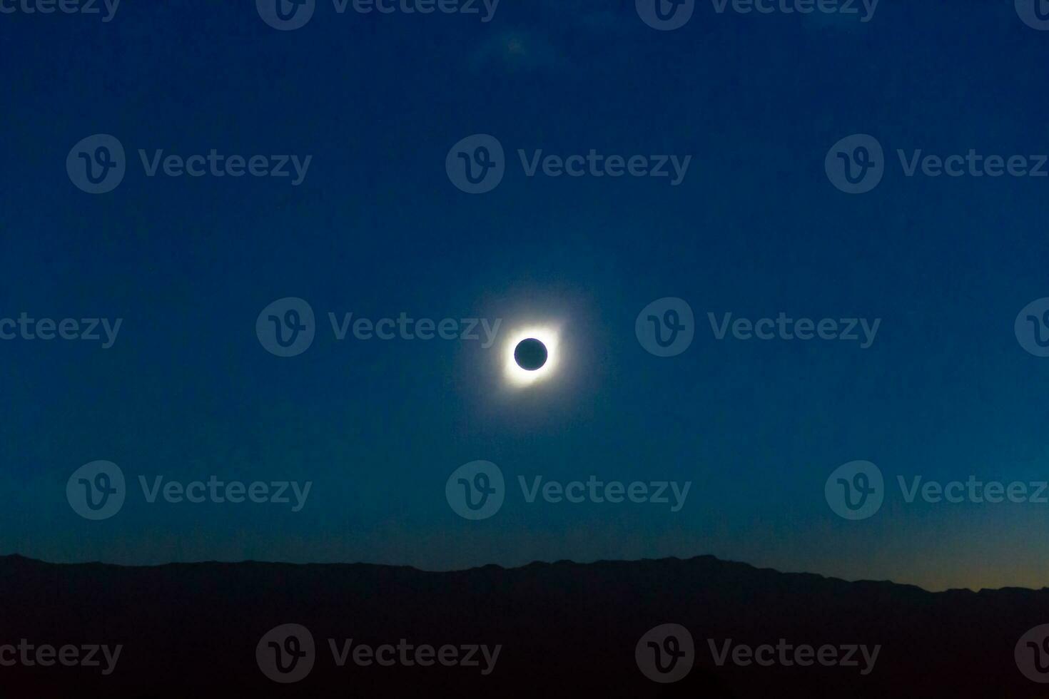 landscape with total eclipse of the sun over the mountains photo