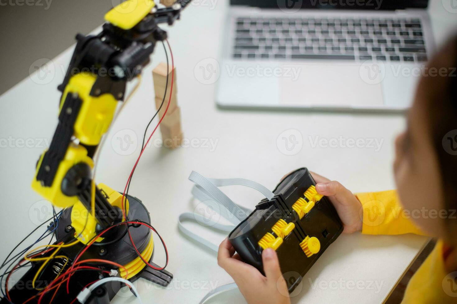 STEM education concept. Asian students learn at home by coding robot arms in STEM, mathematics engineering science technology computer code in robotics for kids' concepts. photo