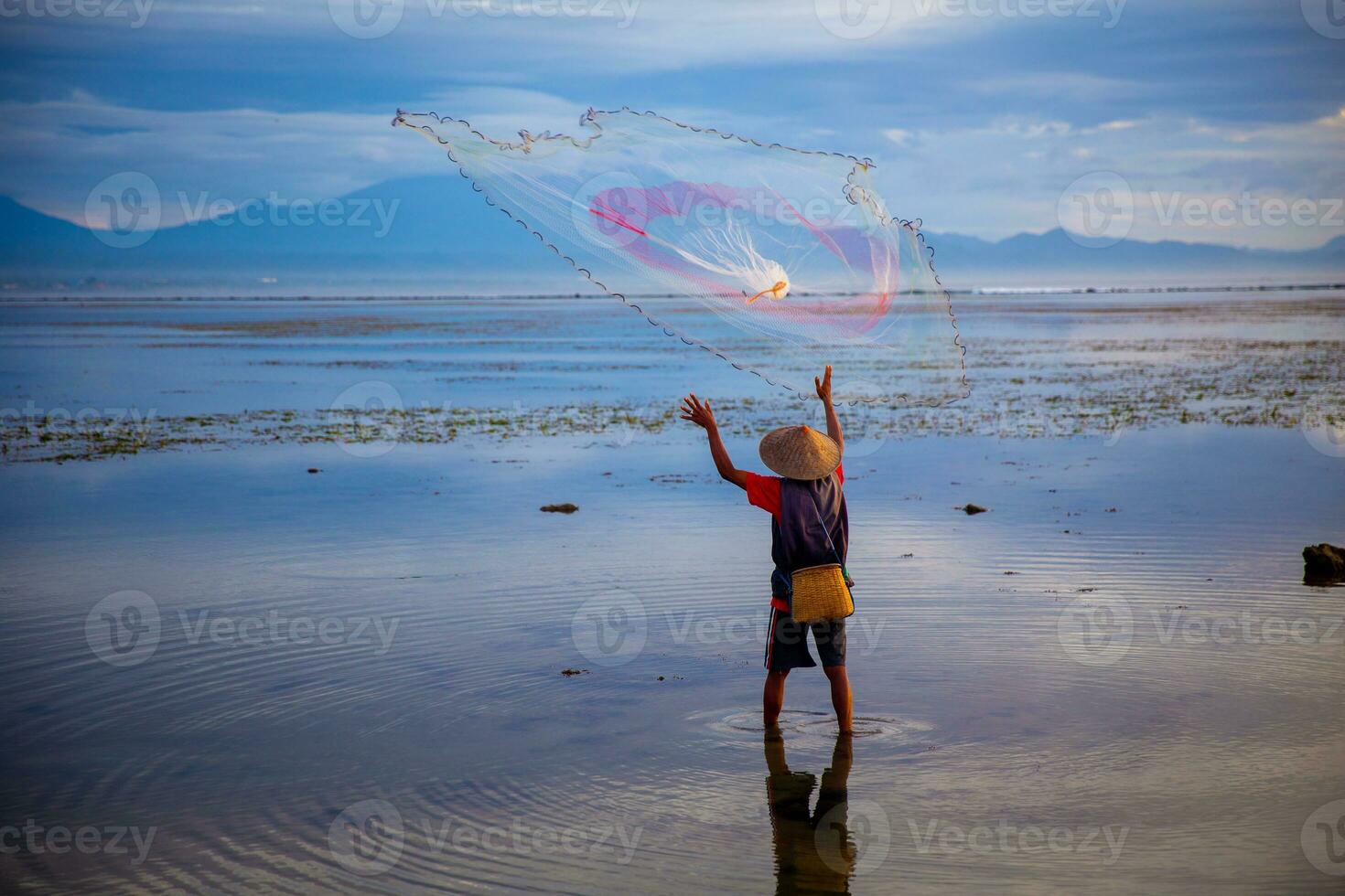Indonesian Fisherman Throwing a Net photo