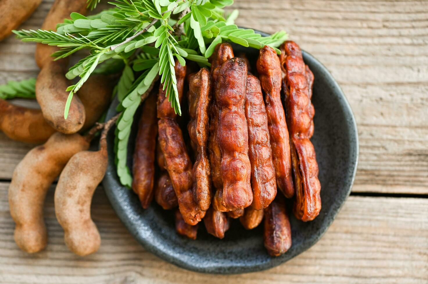 Tamarindo dulce para comida Fruta maduro tamarindos en plato y blanco fondo, Tamarindo pelar en plato tropical frutas verano - parte superior ver foto