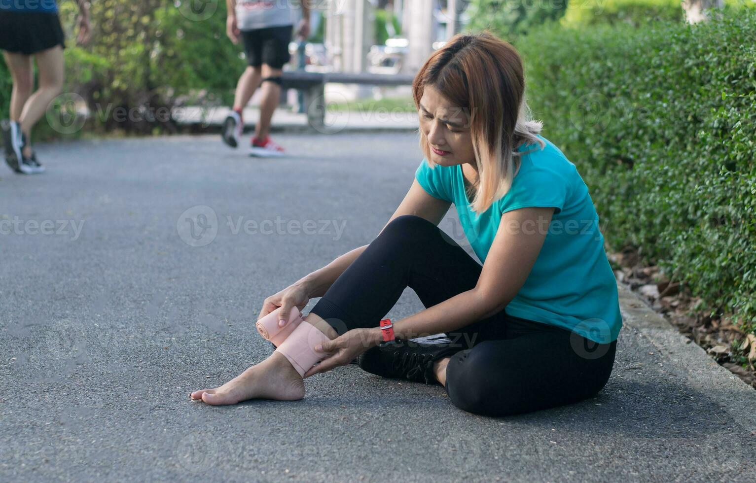 mujer corriendo a el parque sentado en el piso utilizando tobillo vendaje torcido tobillo músculo desde accidente , jota o músculo dolor y problema sensación dolido deporte lesión pierna dolor. foto