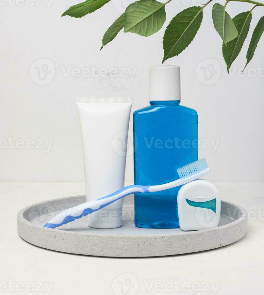 refrescante enjuague bucal en un transparente el plastico botella y dental seda floja en un blanco antecedentes foto