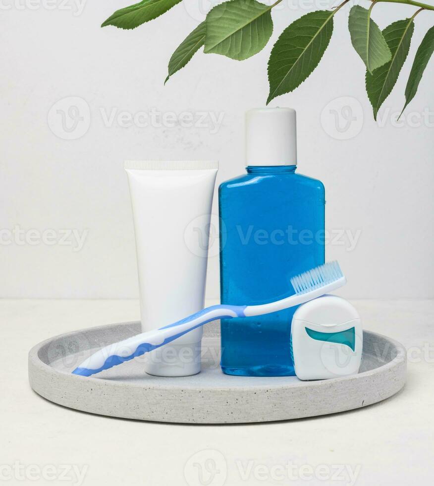 Refreshing mouthwash in a transparent plastic bottle and dental floss on a white background photo