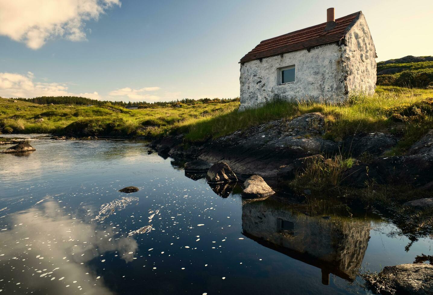 Beautiful nature scene with Gillie's hut, cottage reflected in the river on green meadow at Connemara National park in County Galway, Ireland photo