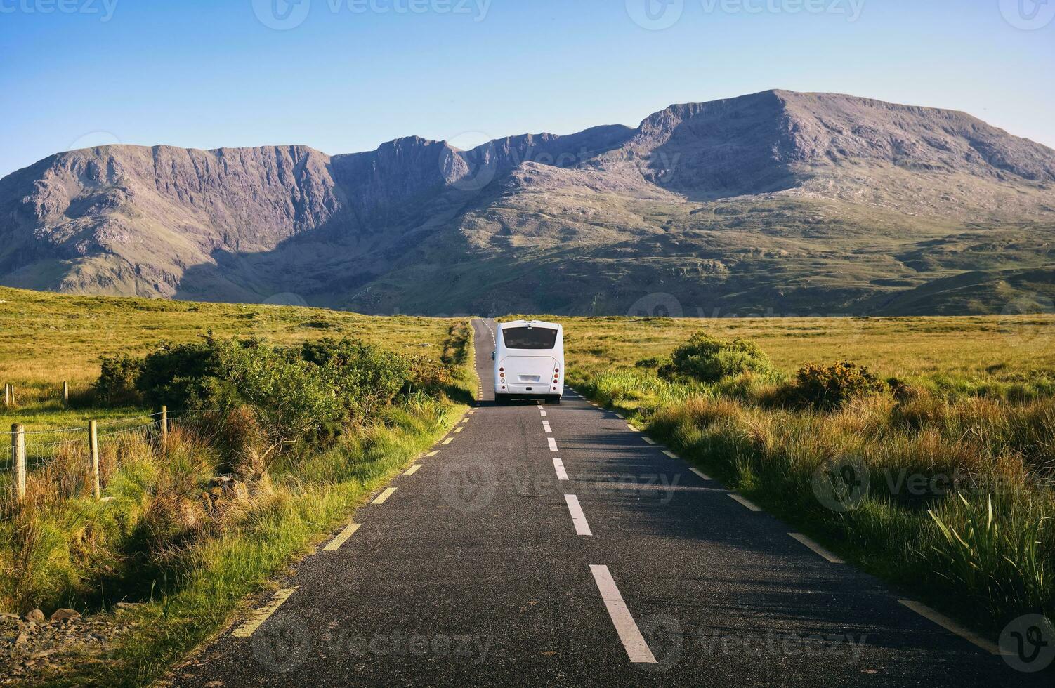 beautiful scene with autobus driving trough scenic nature with mountains in the background at county Mayo, Ireland photo