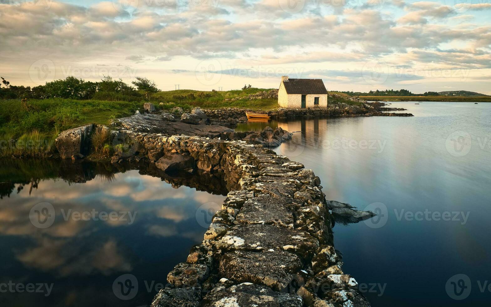 hermosa orilla del lago paisaje con del pescador choza reflejado en lago a pedregal en Connemara nacional parque, condado galway, Irlanda foto