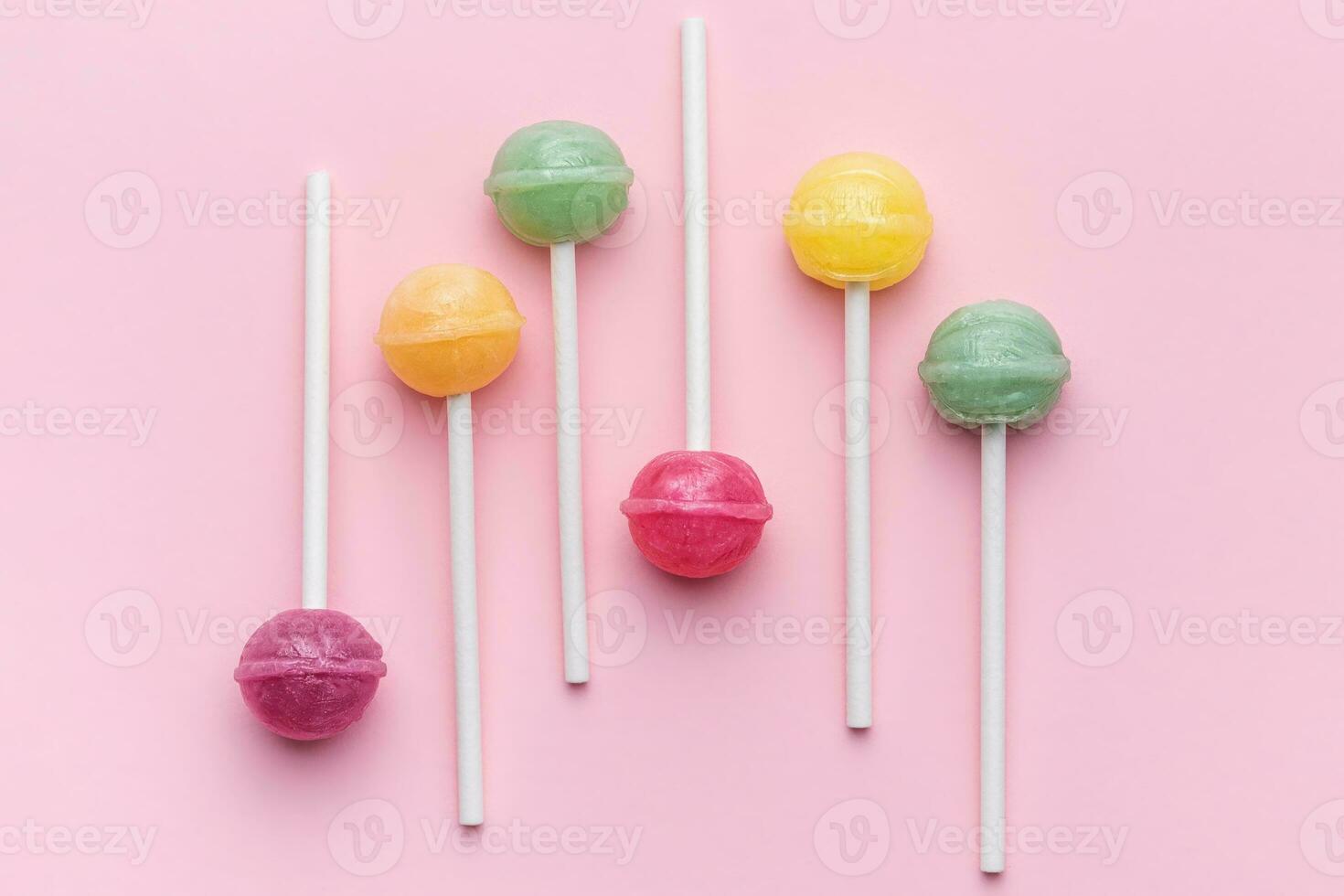 piruletas dulces sobre fondo rosa foto